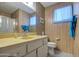 Bathroom features a yellow vanity, shower, and wood paneling at 260 S 72Nd Pl, Mesa, AZ 85208