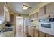 View of kitchen with wood cabinets, white appliances, and tile floor at 260 S 72Nd Pl, Mesa, AZ 85208