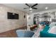Living area with teal sofa, wood floors, and a large TV at 2518 E Campbell Ave, Phoenix, AZ 85016