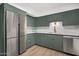 Modern kitchen with stainless steel appliances and green cabinets at 103 E Palm Ln # A, Phoenix, AZ 85004