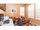 Home office with a leather couch, desk, and window with shutters at 27789 N 129Th Ln, Peoria, AZ 85383