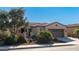Tan house with two car garage and desert landscaping at 27789 N 129Th Ln, Peoria, AZ 85383