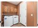 Laundry room with washer, dryer, and wood cabinets at 27789 N 129Th Ln, Peoria, AZ 85383