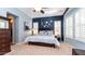 Main bedroom with a king-size bed, window seating and dark blue accent wall at 27789 N 129Th Ln, Peoria, AZ 85383
