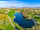 Aerial view of a luxury community with a lake, golf course, and palm trees at 27789 N 129Th Ln, Peoria, AZ 85383