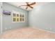 Bedroom with ceiling fan, large window, and mirrored closet doors at 27789 N 129Th Ln, Peoria, AZ 85383