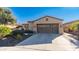 Tan house with two car garage and desert landscaping at 27789 N 129Th Ln, Peoria, AZ 85383