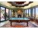 Game room features a billiard table, fireplace, and access to outdoor patio at 11155 E Honda Bow Rd, Scottsdale, AZ 85262