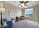 Bright bedroom with large window, comfortable seating, and a crib at 19428 W Colter St, Litchfield Park, AZ 85340