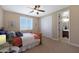 Bright bedroom with double doors leading to bathroom, ceiling fan, and large closet at 19428 W Colter St, Litchfield Park, AZ 85340
