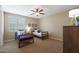 Bedroom with two twin beds, dresser, and ceiling fan at 19428 W Colter St, Litchfield Park, AZ 85340