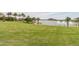 Green lawn with palm trees overlooks a lake with fountains at 18610 W Porter Dr # 93, Goodyear, AZ 85338