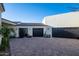 Two-car garage with dark stained doors and paver driveway at 18610 W Porter Dr # 93, Goodyear, AZ 85338