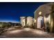 Night view of a stunning Spanish-style home with a welcoming entrance at 18610 W Porter Dr # 93, Goodyear, AZ 85338