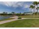 Resort-style pool and lakefront community with palm trees at 18610 W Porter Dr # 93, Goodyear, AZ 85338