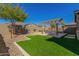 Landscaped backyard featuring a pergola, artificial turf, and stonework at 15298 W Linden St, Goodyear, AZ 85338