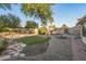 Landscaped backyard with grassy area and stone pathway at 6110 W Charlotte W Dr, Glendale, AZ 85310