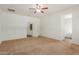 Spacious bedroom with ceiling fan, access to bathroom, and neutral carpeting at 5526 S Grenoble St, Mesa, AZ 85212