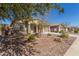 One-story house with a light brown exterior, two-car garage, and landscaped front yard at 43958 W Stonecreek Rd, Maricopa, AZ 85139