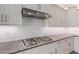 Modern gas cooktop and stainless steel range hood at 43958 W Stonecreek Rd, Maricopa, AZ 85139