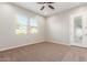 Carpeted bedroom with ceiling fan and sliding glass door at 43958 W Stonecreek Rd, Maricopa, AZ 85139