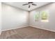 Spacious bedroom with neutral carpeting and two windows at 43958 W Stonecreek Rd, Maricopa, AZ 85139