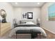 Bright bedroom with a queen-size bed, dresser, and window coverings at 43958 W Stonecreek Rd, Maricopa, AZ 85139