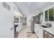 Modern kitchen with white cabinets, stainless steel appliances, and tile flooring at 8301 E Crestwood Way, Scottsdale, AZ 85250