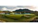 Scenic golf course with a lake, mountain views, and lush green fairways at 21601 W Mariposa St, Buckeye, AZ 85396