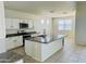 Modern kitchen with island, granite countertops, and stainless steel appliances at 18195 N San Juan St, Maricopa, AZ 85138