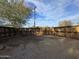 Large backyard with dirt ground and wooden fence at 11126 W Hollywood Ave, Youngtown, AZ 85363