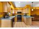 L-shaped kitchen with stainless steel appliances and wood cabinets at 1425 E Desert Cove Ave # 49, Phoenix, AZ 85020