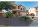 Two-story house with a beige exterior, two-car garage, and desert landscaping at 28614 N Sunset Dr, San Tan Valley, AZ 85143