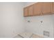 Laundry room with wood cabinets and built-in storage at 28614 N Sunset Dr, San Tan Valley, AZ 85143