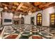 Spacious living area with a stone fireplace, high ceilings, and geometric tile floor at 8100 N 68Th St, Paradise Valley, AZ 85253