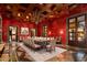 Formal dining room with red walls, wood ceiling, and marble floors at 8100 N 68Th St, Paradise Valley, AZ 85253