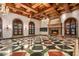 Grand living room with exposed wood beams, a fireplace, and a geometric tile floor at 8100 N 68Th St, Paradise Valley, AZ 85253