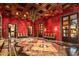 Formal dining room with red walls, wood ceiling, and marble floors at 8100 N 68Th St, Paradise Valley, AZ 85253