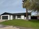 Ranch style home with black and white exterior, landscaped lawn, and a two-car garage at 5518 W Boca Raton Rd, Glendale, AZ 85306