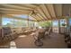 Relaxing screened porch with wooden flooring and seating area at 50910 W Long Rifle Rd, Aguila, AZ 85320