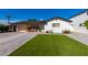 White single story home with artificial turf lawn and a wood fence at 4002 E Clarendon Ave, Phoenix, AZ 85018