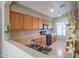 View of kitchen with wood cabinets, black appliances, and double sink at 18116 N Catherine Dr, Surprise, AZ 85374