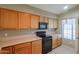 Kitchen with wood cabinets, black appliances, and ample counter space at 18116 N Catherine Dr, Surprise, AZ 85374