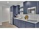 Small kitchenette with dark blue cabinets and white subway tile backsplash at 511 E Tumbleweed Dr, Phoenix, AZ 85085