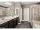 Elegant bathroom with double sinks, a large mirror, and a walk-in shower at 1695 E Mia Ln, Gilbert, AZ 85298