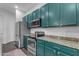 Modern kitchen with teal cabinets and granite countertops at 964 W Saguaro Ln, San Tan Valley, AZ 85143