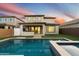 Two-story home with a sparkling pool and spa, lush landscaping, and a covered patio at 19834 W Rancho Dr, Litchfield Park, AZ 85340