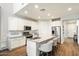 Modern kitchen with white cabinets, granite countertops, and island seating at 19834 W Rancho Dr, Litchfield Park, AZ 85340