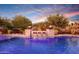 Luxury pool with fire pit and waterfall feature at sunset at 20594 W Pasadena Ave, Buckeye, AZ 85396
