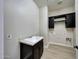 Laundry room with dark cabinets, a utility sink and tile floor at 20594 W Pasadena Ave, Buckeye, AZ 85396
